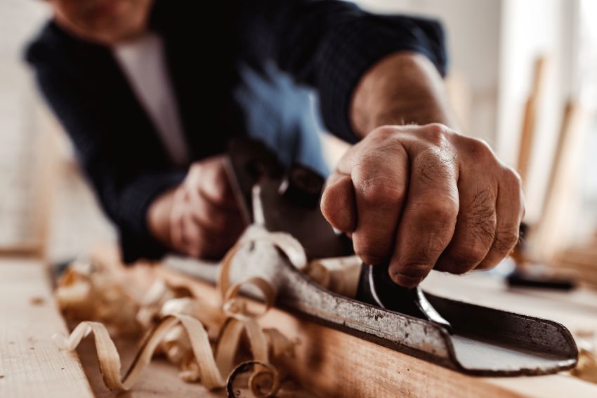 carpenters-hands-planing-a-plank-of-wood-with-a-hand-plane.jpg